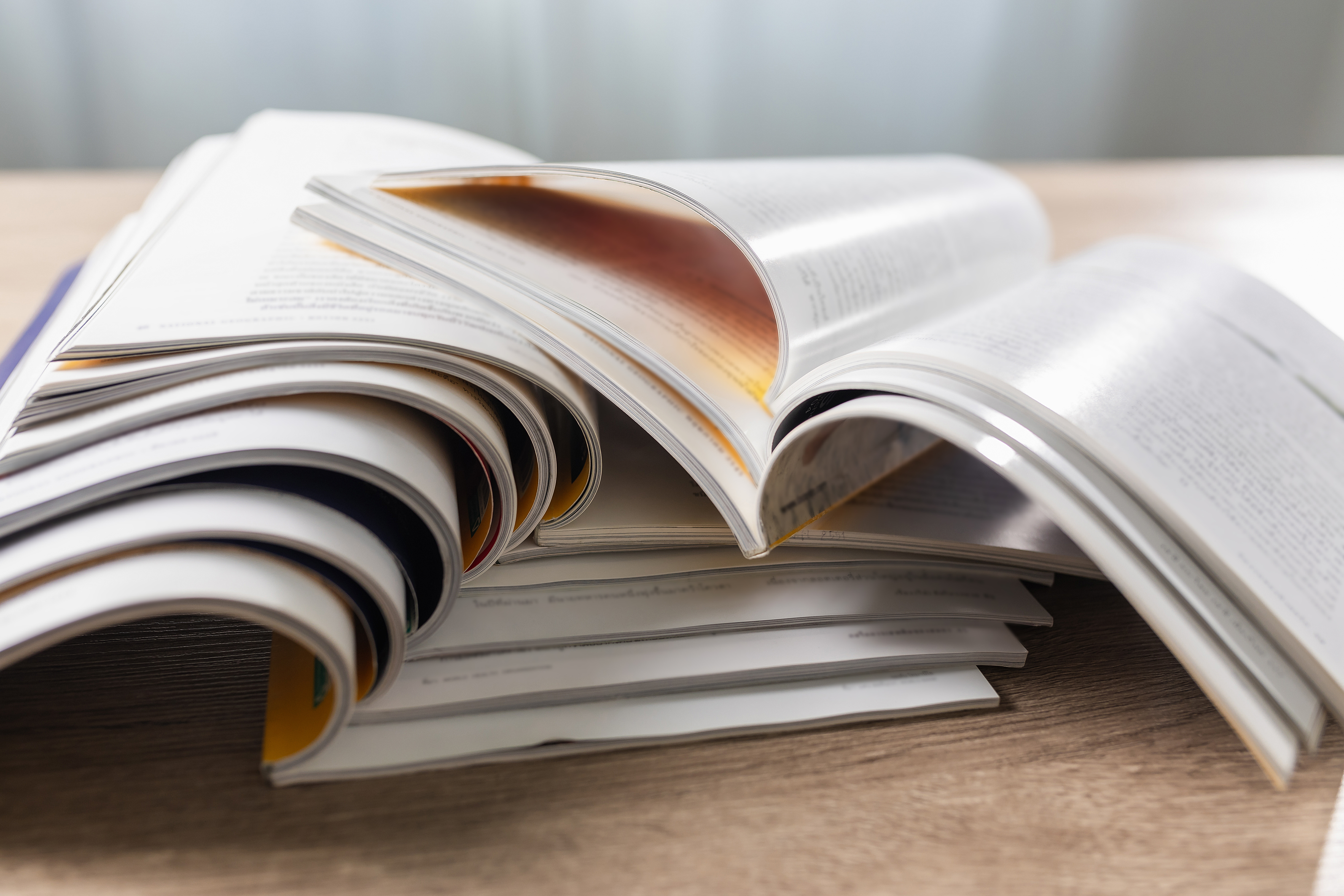 stack of journals with top one open on a desk